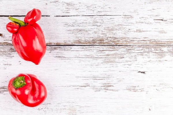 Funny ugly farm vegetables sweet red bell peppers with mutations on wooden table — Stock Photo, Image