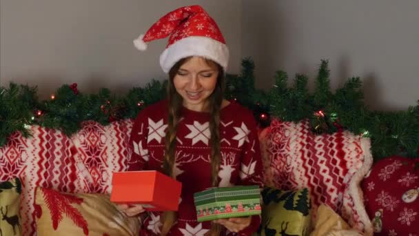 Dziewczyna wybierając z dwóch pudełek świątecznych w Nowy Rok dekoracje świąteczne — Wideo stockowe
