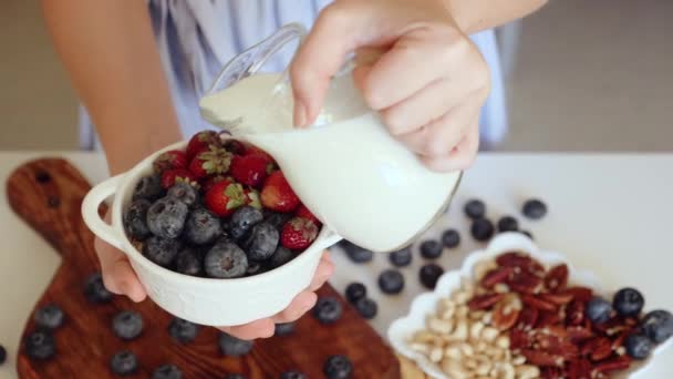 Donna mano che tiene vegetariano prima colazione ciotola, versando latte, concetto di cibo fresco — Video Stock