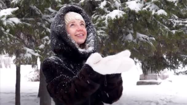 Joyeux sourire belle femme attrapant des flocons de neige dans ses gants blancs fourrure — Video