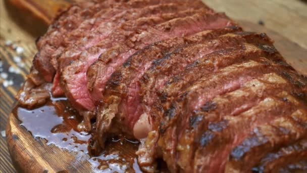 Close Up de bife de carne grelhada fatiada com especiarias na placa de corte de madeira — Vídeo de Stock