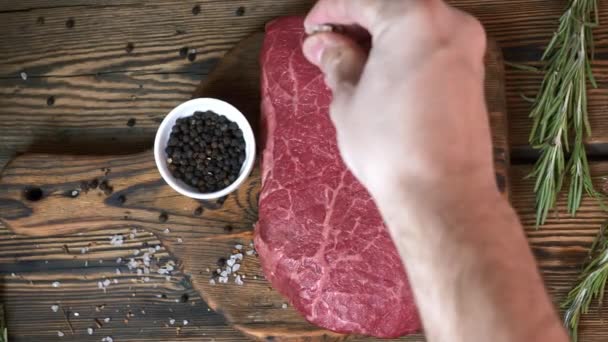 Séf Salt a nyers friss steak bors és rozmaring a fa vágódeszka — Stock videók