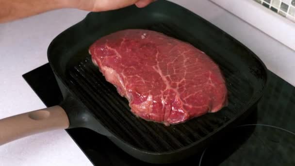 Шеф-повар Соль сырой свежий стейк на гриль-кастрюле на белой кухне, мраморное мясо — стоковое видео