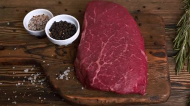 Erkek El, Biber ve Tuz ile servis edilen çiğ taze biftek üzerine bir dal biberiye ekler.