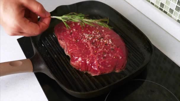 Чоловік кладе перуку Розмарі на смажену яловичину стейк з сіллю і перцем — стокове відео
