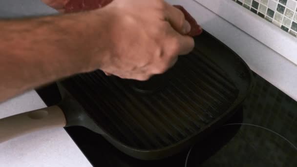 Человек руки положить свежий стейк говядины на сковороду на кухне, процесс приготовления пищи — стоковое видео