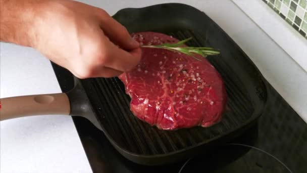 Hombre mano poniendo ramita de romero en carne de res a la parrilla con sal y pimienta — Vídeos de Stock