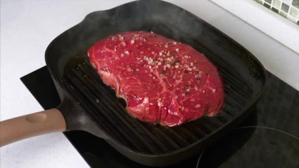 Pomalý pohyb ručně posypané soli na grilovaném hovězím steaku na grilované pánvi — Stock video