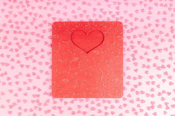 Красная карточка Валентины с украшением сердца маленькими сердечками на розовом фоне — стоковое фото