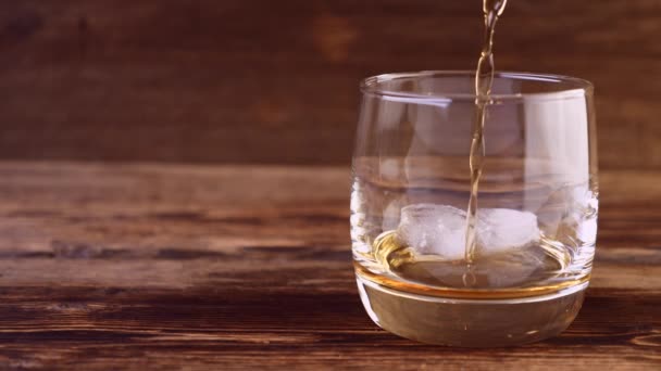 Primer plano de verter whisky con cubitos de hielo en vidrio — Vídeos de Stock