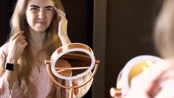 Young Woman Looking in Mirror and Dissatisfied with Her Eyebrows Dye — ストック動画