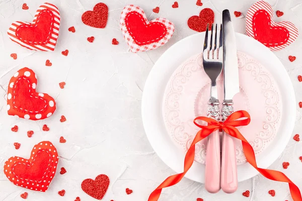White and Pink Plates with Fork, Knife and Red Ribbon Bow with Decorative Hearts