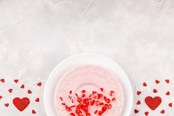 Valentijn achtergrond met platen met rode takken en papieren harten Confetti — Stockfoto