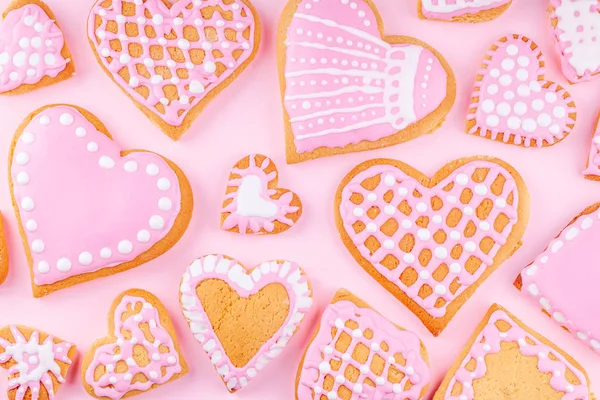 Handgemaakte geglazuurde gedecoreerde hartvormige cookies op roze achtergrond — Stockfoto