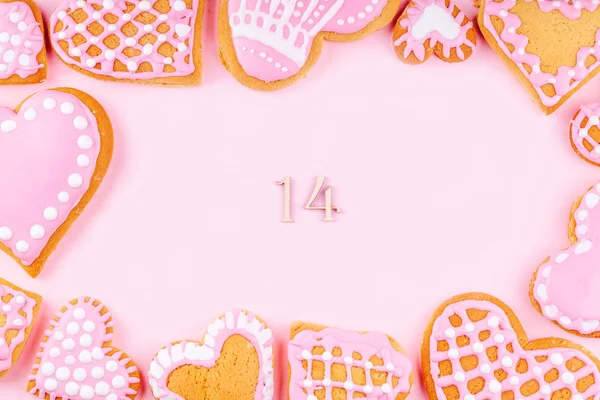 Frame van handgemaakte geglazuurde gedecoreerde hartvormige cookies op roze achtergrond — Stockfoto