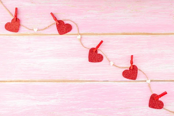 Jute Touw met Rode Glitter Harten, Pinnen en Confetti Harten op Roze Achtergrond — Stockfoto