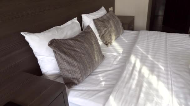 枕付きのクイーンサイズベッドと新鮮なベッドリネンの美しいホテルの部屋 — ストック動画