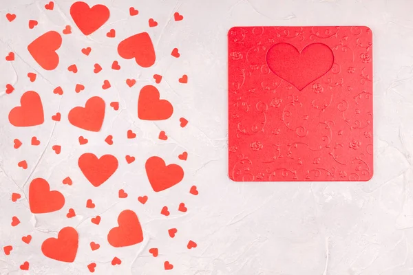 Caja de regalo con lazo de cinta roja, tarjeta de San Valentín y corazones de papel Confetti — Foto de Stock
