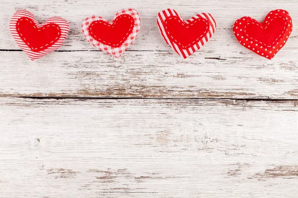 Costura corazones de almohada fila frontera de tela roja en rústico fondo de madera blanca — Foto de Stock