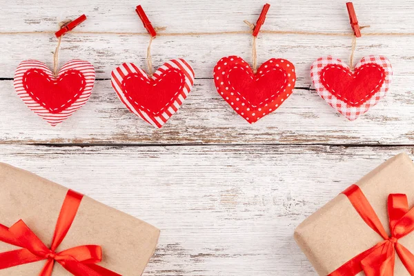 Ράψιμο μαξιλάρι καρδιές γραμμή συνόρων από κόκκινο ύφασμα, κουτιά δώρων με κόκκινη κορδέλα — Φωτογραφία Αρχείου