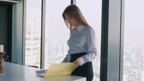 Businesswoman in the Office Leafing Folder with Documents Near the Window — ストック動画