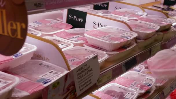 Paquete de devolución de mano de mujer con carne de cerdo a estante en el refrigerador en el supermercado — Vídeos de Stock