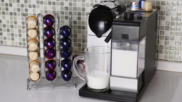 Machine à café automatique avec capsules de café est versé lait chaud dans une tasse en verre — Video