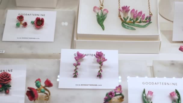 Hermosas joyas en la tienda Estantes hechos en forma de manzanilla, orquídeas, tulipán — Vídeo de stock