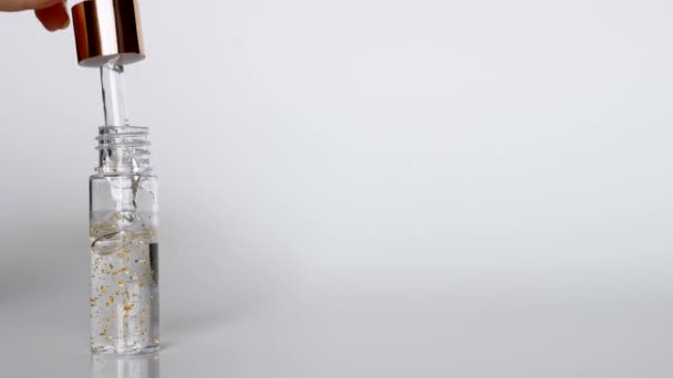 Serum with Gold Drops Falling from the Cosmetic Pipette on White Background — Stock Video