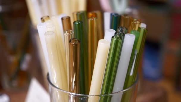 Красочные многоразовые пластиковые соломинки для питья в стеклянных банках в экологическом магазине — стоковое видео