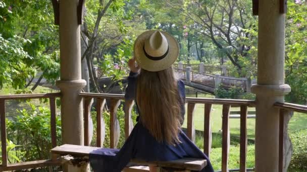 Traveler žena sedí v zeleném parku, těší příroda, relaxace a klid — Stock video