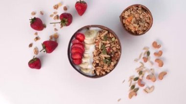 Woman Hand Sprinkle Pumpkin Nuts in Bowl with Granola, Nuts, Fresh Fruits