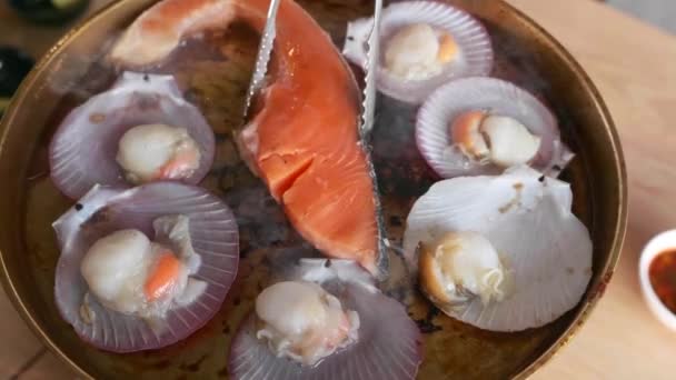Frisches Lachssteak und Jakobsmuscheln auf Schale in Pfanne im Restaurant — Stockvideo