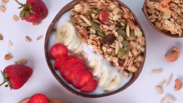Gros plan du bol à smoothie rotatif avec fraise, noix et granola — Video