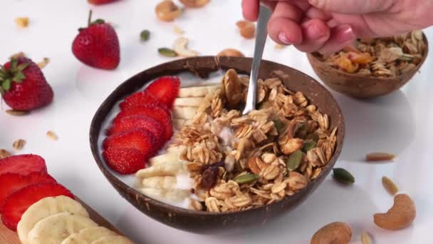 Mano de mujer con cuchara Tome Granola de Smoothie Bowl con frutos secos y frutas frescas — Vídeo de stock