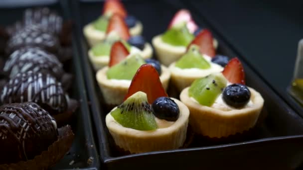 Small Sweet Cakes with Fresh Berries on the Cafe Display Case — Stock Video