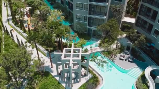 Volo aereo drone sopra la piscina e giardino con palme nell'area comune di Condo — Video Stock