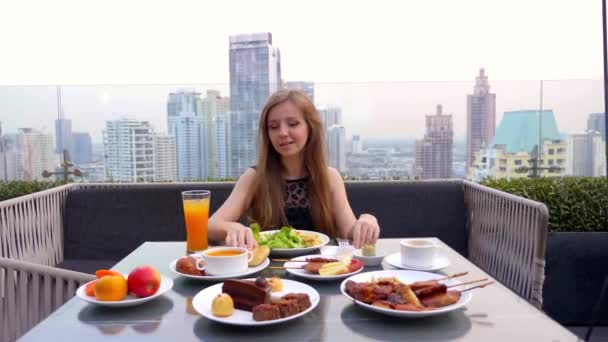 Jovem Senhora Jantar Sozinha em uma Cidade Moderna Rooftop Restaurante no início da noite — Vídeo de Stock