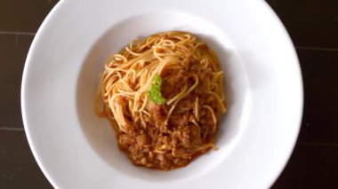 Beyaz tabakta siyah masada taze pişmiş spagetti bolonez manzarası.