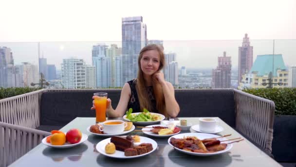 Mujeres sentadas en la mesa con comida y bebida en el restaurante al aire libre en la azotea — Vídeos de Stock