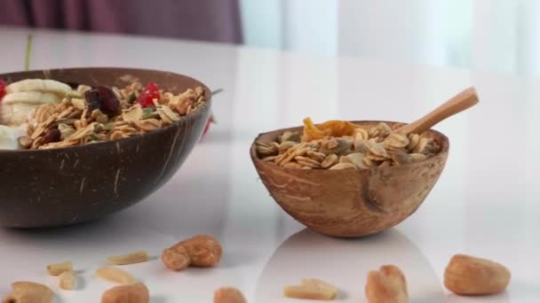 Tazón de coco con Granola, Harina de avena, Nueces, bayas frescas y frutas — Vídeos de Stock