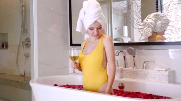 Jonge aantrekkelijke vrouw Holding Glass met Champagne in bad met rozenblaadjes — Stockvideo