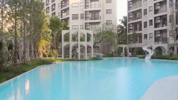 Gran piscina vacía con agua azul entre árboles tropicales en la luz del atardecer — Vídeo de stock