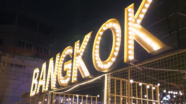 Světelné znamení žárovek se slovem Bangkok na vstupu na večerní trh — Stock video