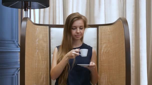 Sorridente bella donna seduta nel caffè, bere una tazza di caffè e rilassarsi — Video Stock