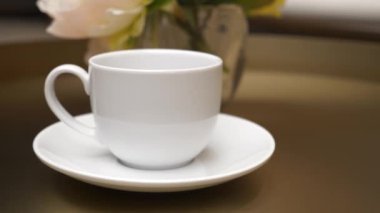 Bir fincan çay ya da kahve Kafe 'de tahta bir masanın üzerinde duruyor. 