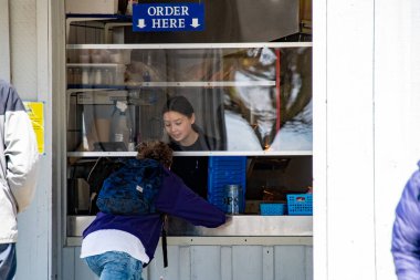 COVID-19 salgını sırasında işçileri ve müşterileri korumak için pleksiglas kullanılarak bir parkta bulunan balık ve patates cipsi deposu. Richmond BC Kanada 25 Nisan 2020 