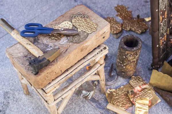 Banco artigiano con utensili per incidere artigianato in ottone — Foto Stock
