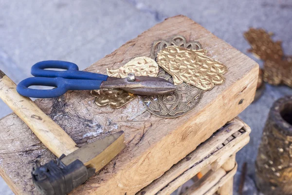 Řemeslník lavice s nástroji pro gravírování mosaz řemesla — Stock fotografie