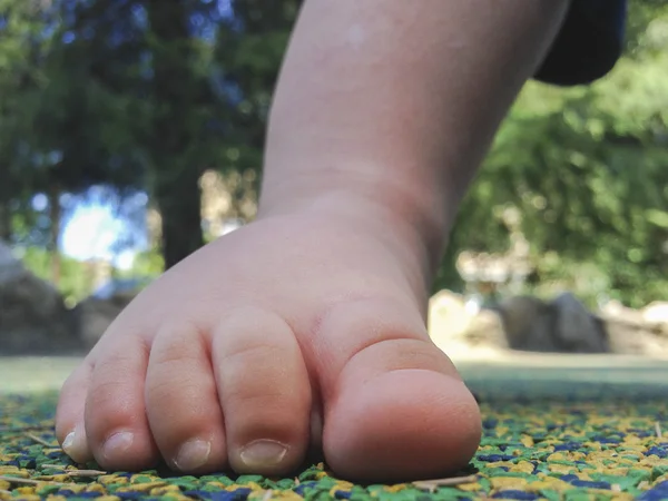 Piede ragazzo sul pavimento di gomma — Foto Stock